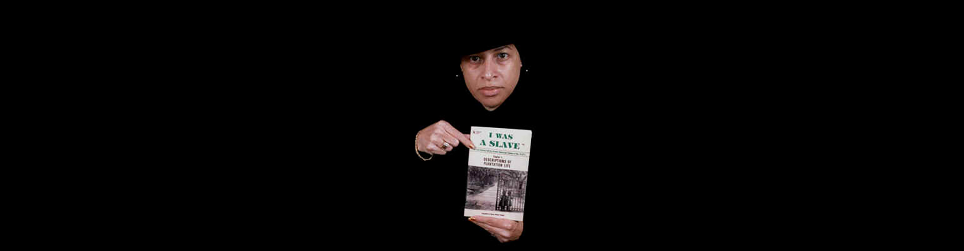 Compiler Donna Wyant Howell holding a copy of I WAS A SLAVE books