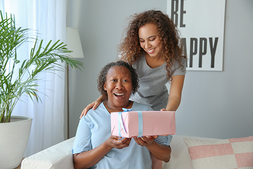 Young woman giving box of I WAS A SLAVE books to grandmother